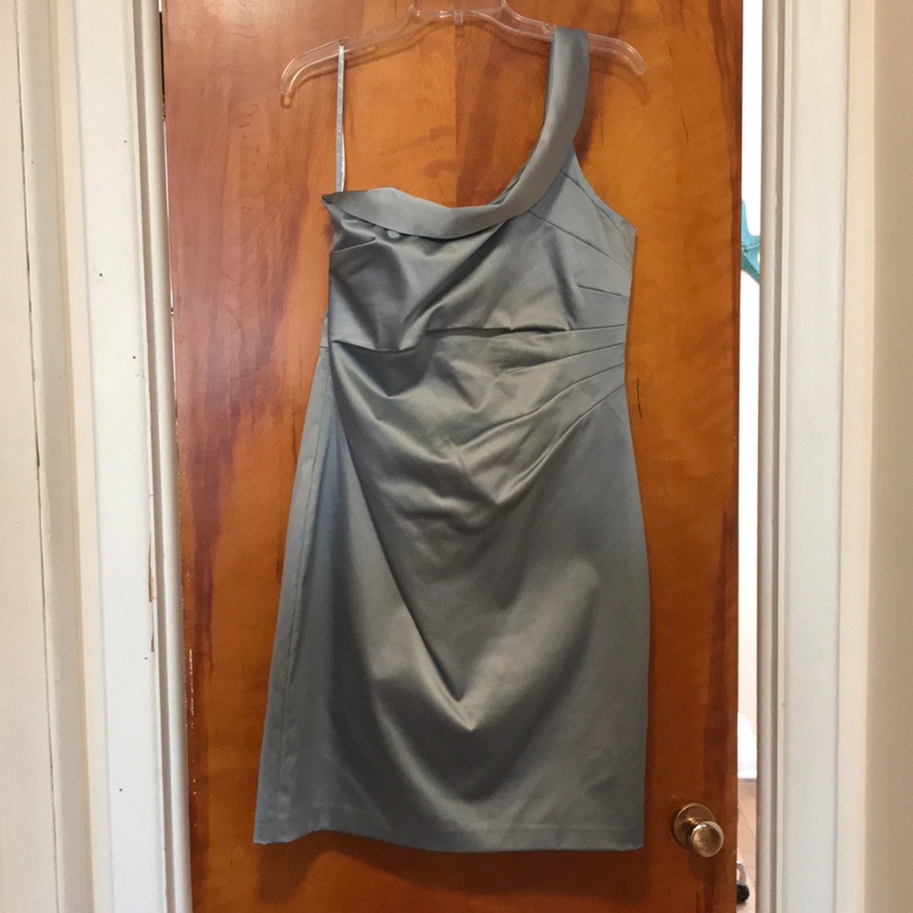 Silver knee length, one shoulder gown.